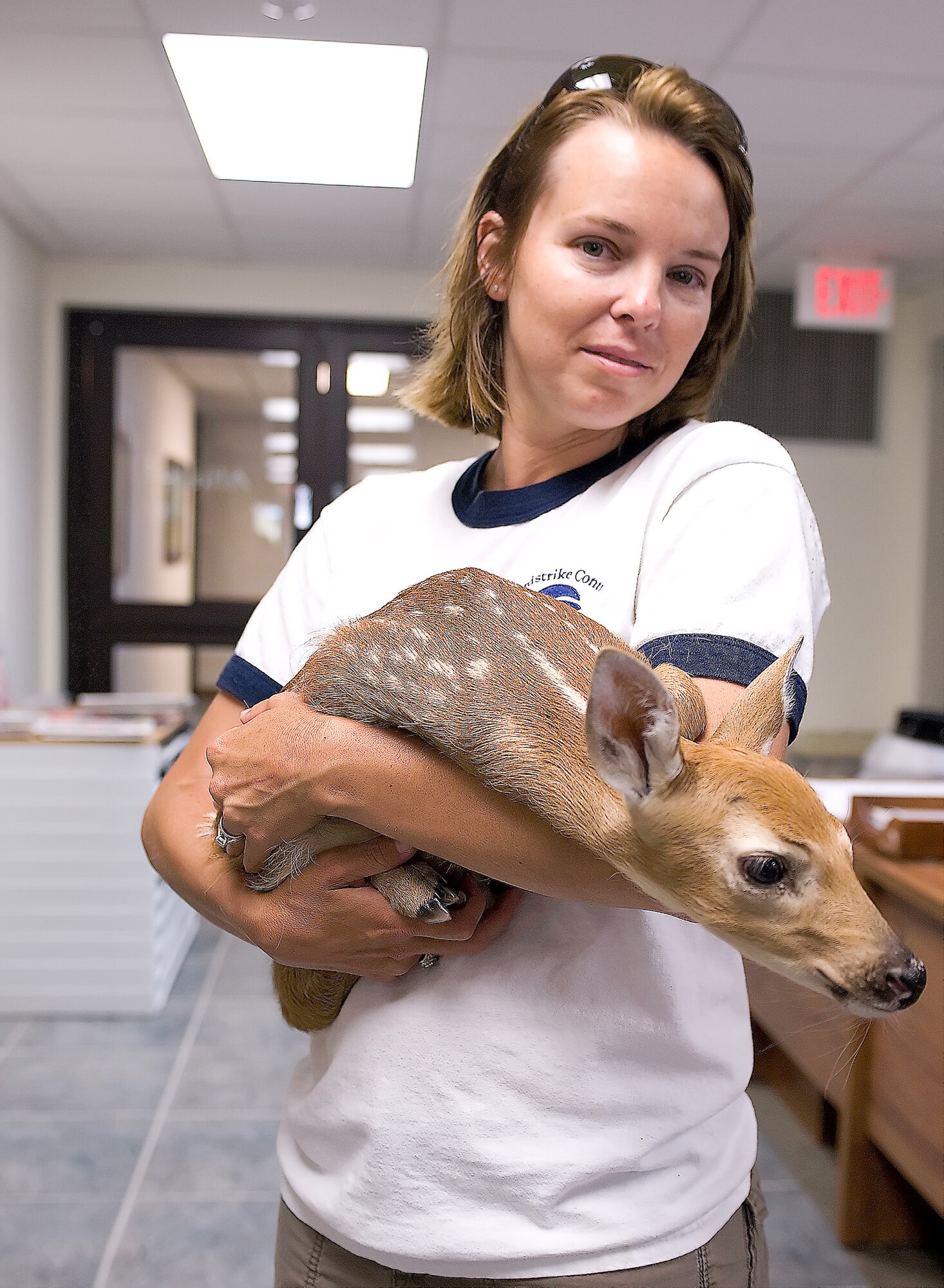 Melody Henderson holds a fawn she rescued June 9, 2011, from the flightline at Dover Air Force Base, Del. Mrs. Henderson is a bird/wildlife aircraft strike hazard ecologist and wildlife manager. She is part of an effort by the Air Force to minimize bird strikes. (U.S. Air Force photo/Steve Kotecki) 
