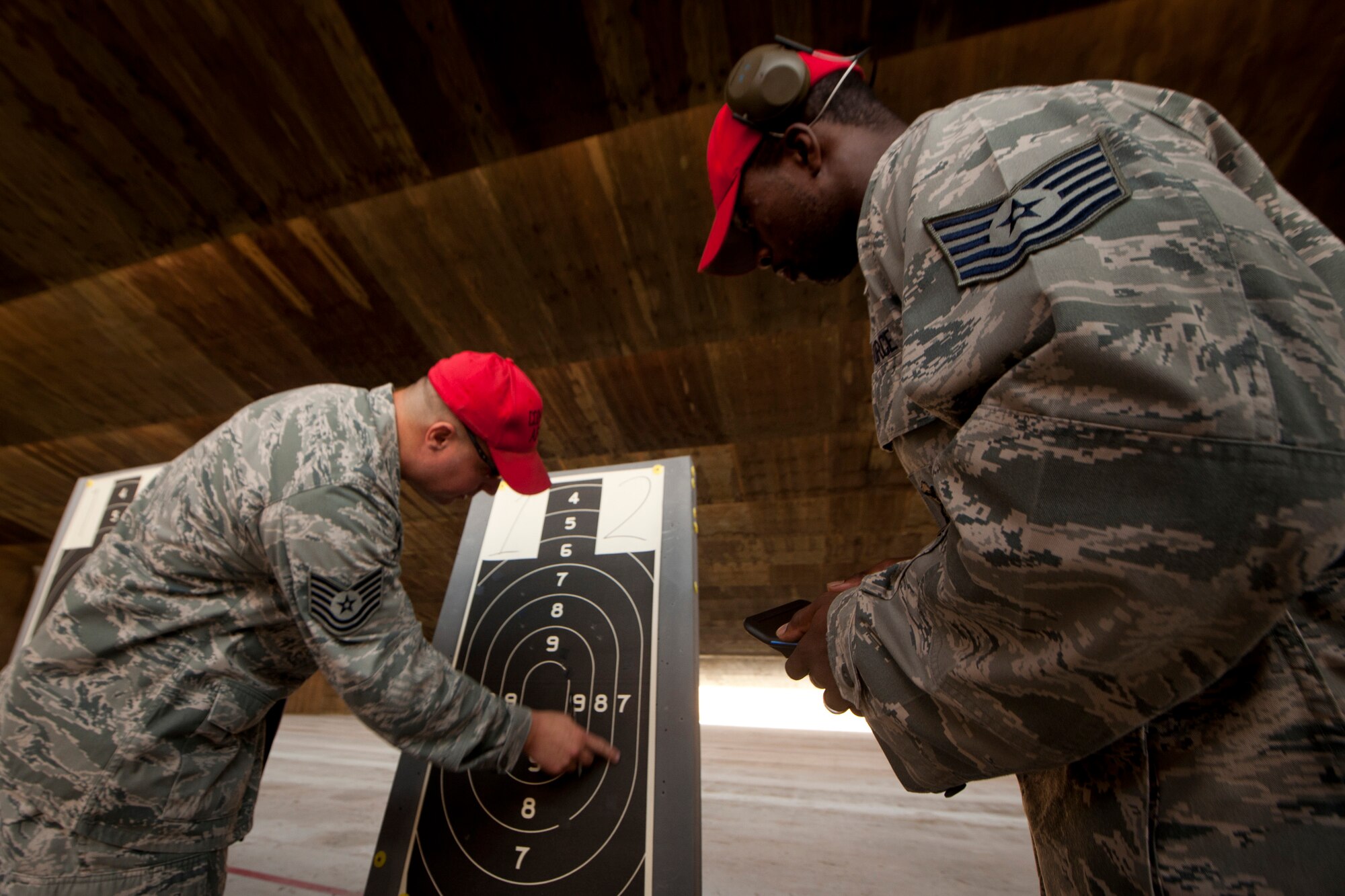 U.S. Air Force Tech. Sgts. Kevin Whitlock and Elizah Mitchell, 820th Combat Operations Squadron combat arms instructors, check targets for marks and calculate points during the Excellence In Competition Shooting event at Moody Air Force Base, Ga., June 21, 2011. During the competition, Airmen shot from 25 yards away, one-handed, two-handed and rapid fire. (U.S. Air Force photo by Airman 1st Class Joshua Green/Released)                 