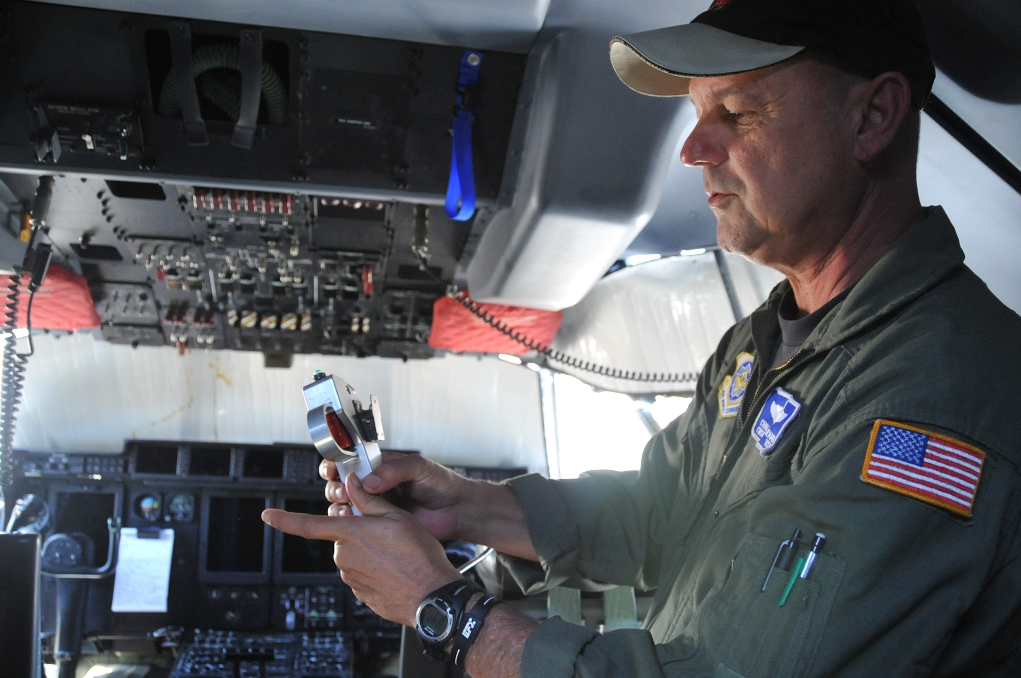 KIRTLAND AIR FORCE BASE, N.M. -- Chief Master Sgt. Jimmy Dehart, 115th Air Expeditionary Airlift Squadron chief loadmaster, California Air National Guard, Channel Islands Air National Guard Station, Calif., stands in the cockpit of a C130J explaining a Modular Airborne Fire Fighting System’s trigger device that releases the water or retardant used to fight wildfires. In support of the National Interagency Fire Center, the unit brought two C-130J aircraft equipped with MAFFS to help control wildfires in the Southwestern U.S. (Air Force photo by Elizabeth Martinez.)