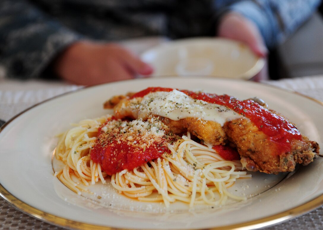 U.S. Army Priority Air Transport Command, flight stewards serve chicken parmesan to service members during a training flight from Joint Base Andrews Md., June 21.  All food cooked in-flight is homemade prepared fresh for each mission.  As the face of USAPAT flight stewards ensure the safety, security and comfort of all passengers aboard the blue and white C-37A aircraft. (U.S. Air Force photo/ Staff Sgt. Nichelle Anderson)