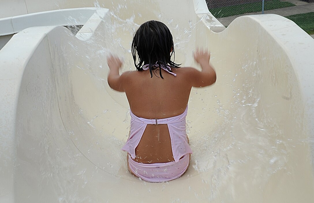 Sarah Trantham, 7, goes down the slide at the Shellbank outdoor pool at Langley Air Force Base, Va., June 19, 2011. A swim test is administered for all youth 12 years of age and younger before they are permitted to use the diving board or slide. (U.S. Air Force photo by Airman 1st Class Teresa Cleveland/Released)