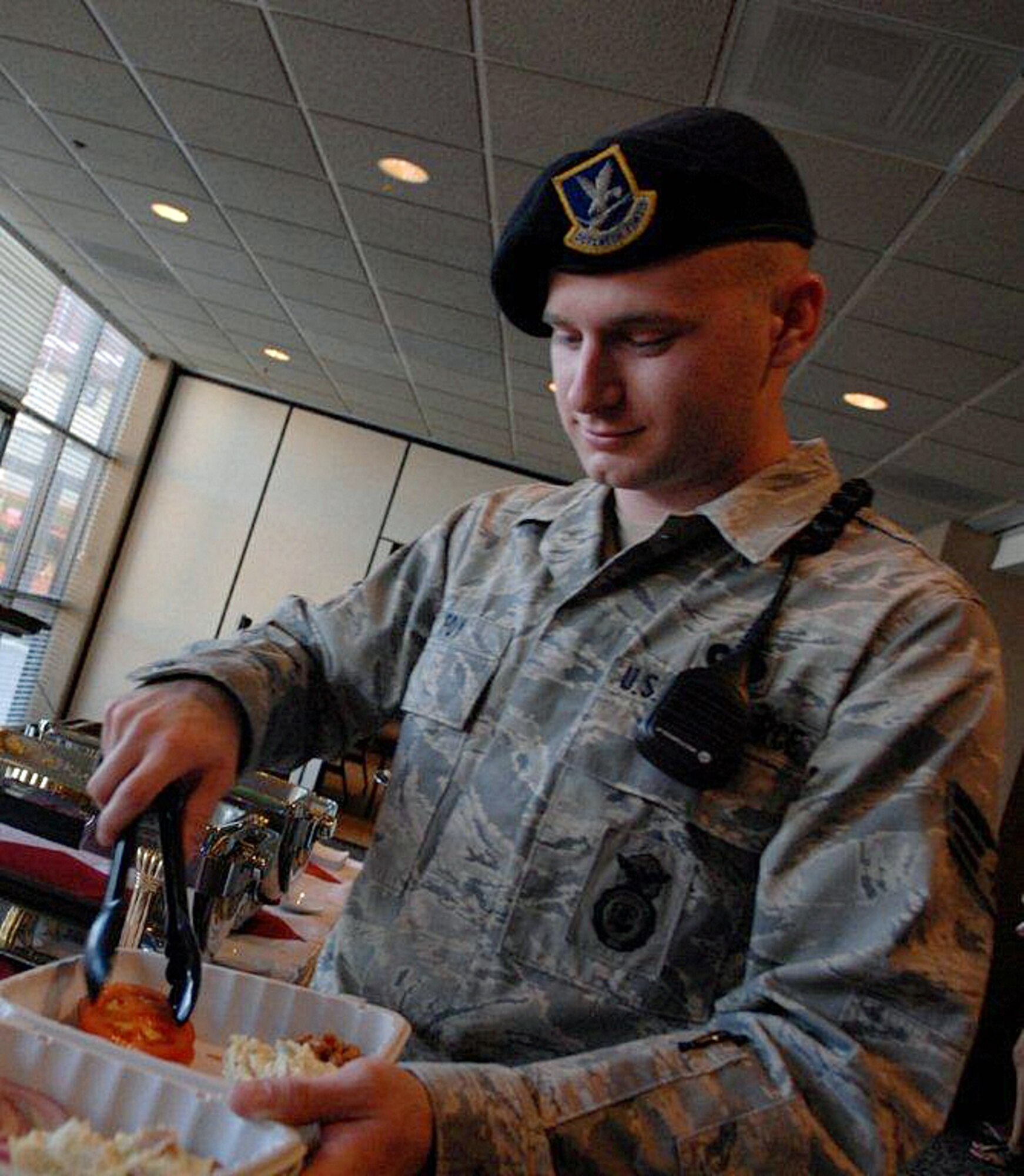 Senior Airman Brandon Foy, 95th Security Forces Squadron patrolman, fixes himself a to-go box at the American Red Cross Airmen and Marine Appreciation Dinner, June 14 at Club Muroc. The dinner was sponsored by the Red Cross as part of an effort to foster a sense of community for Airmen and Marines who live in the dormitories. (Air Force photo by Veronica Buening)