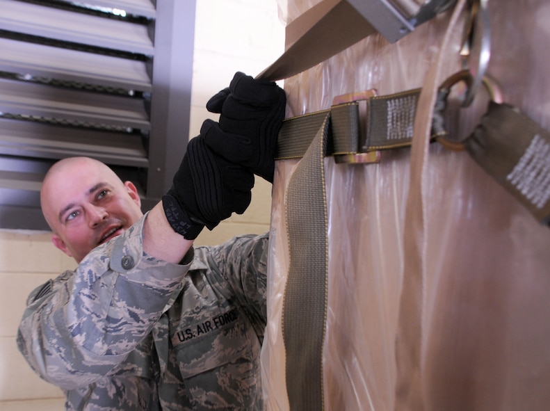 Joint Base Charleston, SC -- Most people aren't aware of the dangerous effects of gravity, but it is Staff Sgt. Duane Olds' stock and trade.  The load planner with the 437th Aerial Port Squadron has the responsibility of calculating the potential gravity forces cargo will endure in an airplane and prepares cargo shipments to withstand it.  He takes his job seriously because he often deals with precious cargo -- in this case, food for disaster relief.  (Official U.S. Air Force photo by Staff Sgt. Shawn Rhodes)