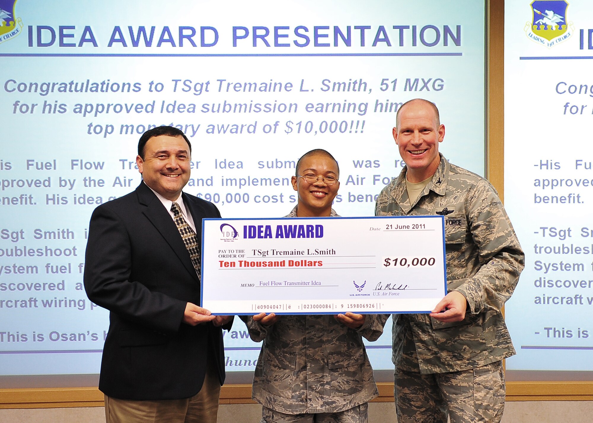Col. Patrick Malackowski and Ed Moreno present Tech. Sgt. Tremaine Smith with a check for $10,000 June 21, 2011, at Osan Air Base, South Korea. Sergeant Smith was recognized through the Innovative Development Employee Awareness program for an idea that fixed a fuel-flow transmitter problem, saving the Air Force more than $90,000 in replacement costs over the next year. (U.S. Air Force photo/Senior Airman Evelyn Chavez)