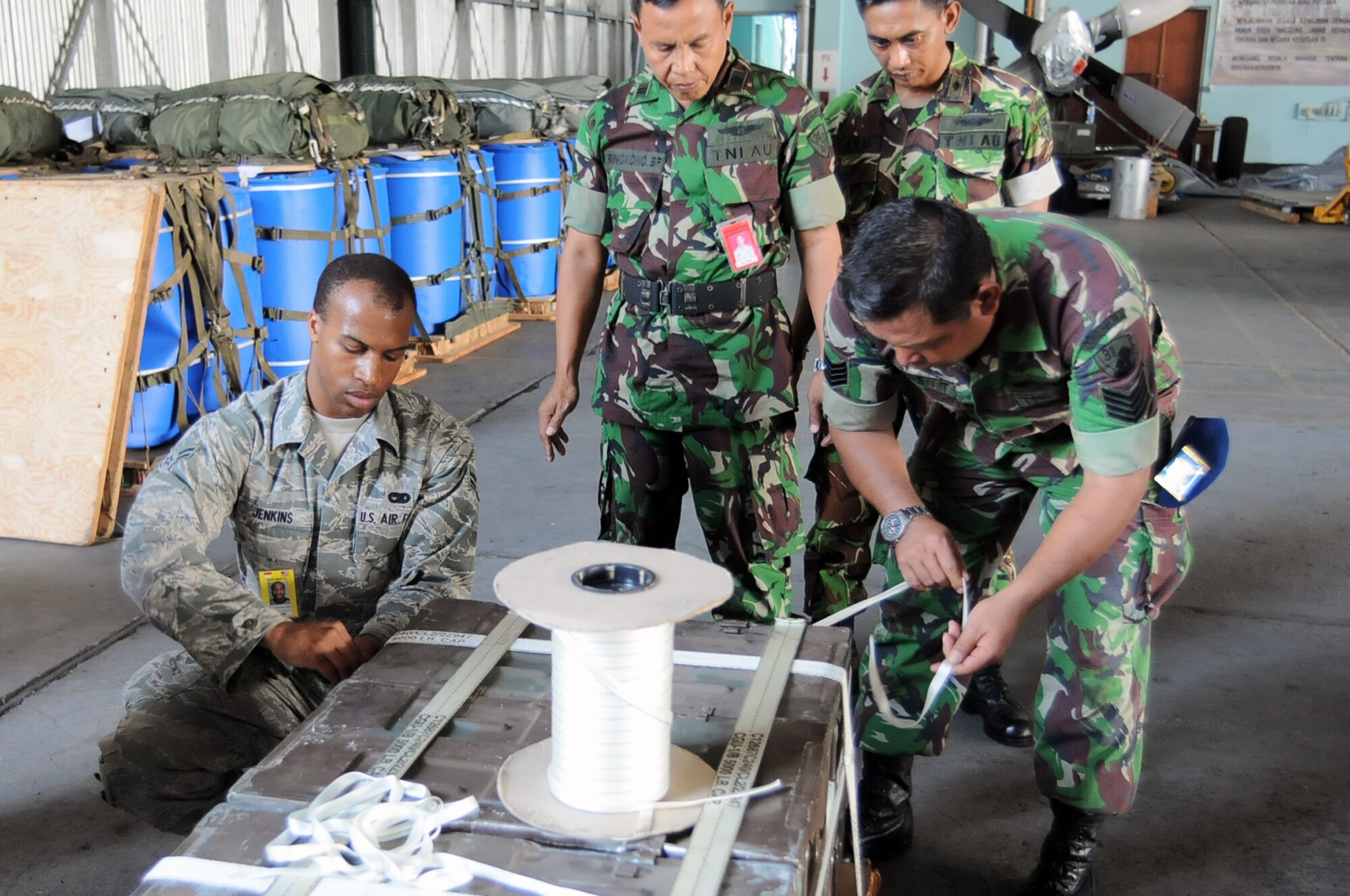HALIM AIR BASE, Indonesia -- Airman 1st Class Brandon Jenkins, a rigger with the 374th Logistics Readiness Squadron's Combat Mobility Flight works with an Indonesian Air Force rigger to build a Low-Cost, Low-Altitude bundle during a rigging lesson at Exercise Cope West 11 at Halim Air Base, Indonesia, June 22, 2011. The training seminar, one of several scheduled during the exercise, was designed to encourage information exchange between US and Indonesian forces and promote better interoperability for future combined missions. (U.S. Air Force photo/Capt. Raymond Geoffroy)
