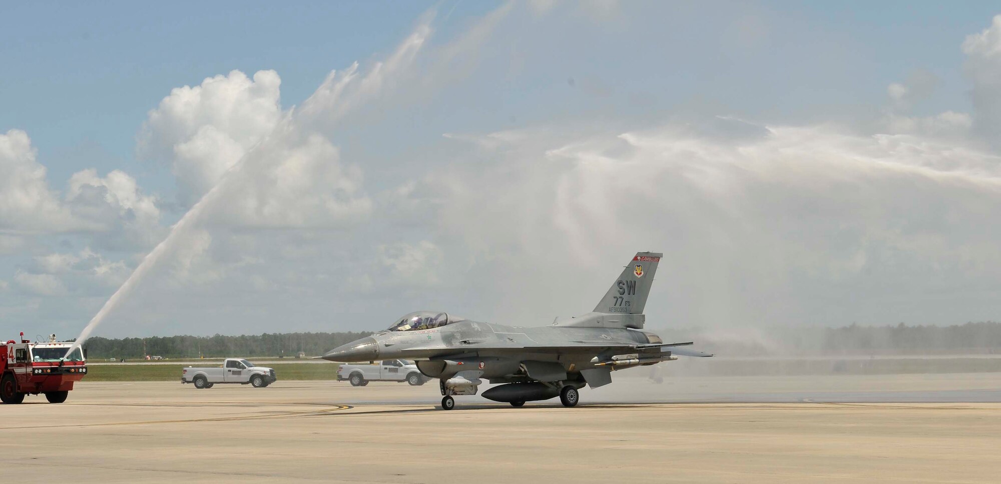 Col. John Colombo, Air Forces Northern, taxies his F-16 through the water spray of two fire trucks after his fini-flight at Tyndall Air Force Base, Fla., June 20. During his 24-year career as a fighter pilot, Colonel Colombo flew 3,570 hours. (U.S. Air Force photo by Lisa Norman)