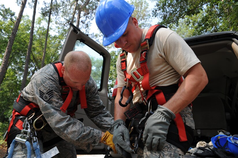 Staff Sgt. John Kingsley assists Tech. Sgt. Nathan Swab with a safety harness in preparation for a training climb of a radio frequency tower at Joint Base Charleston - Weapons Station June 14. Sergeant Kinglsey and Sergeant Swab are radio frequency transmissions craftsmen with the 628th Communications Squadron. (U.S. Air Force photo/Staff Sgt. Katie Gieratz)