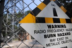 A sign warns visitors of danger while Airmen from the 628th Communications Squadron climb a radio frequency tower at Joint Base Charleston - Weapons Station, June 14. (U.S. Air Force photo/Staff Sergeant Katie Gieratz)