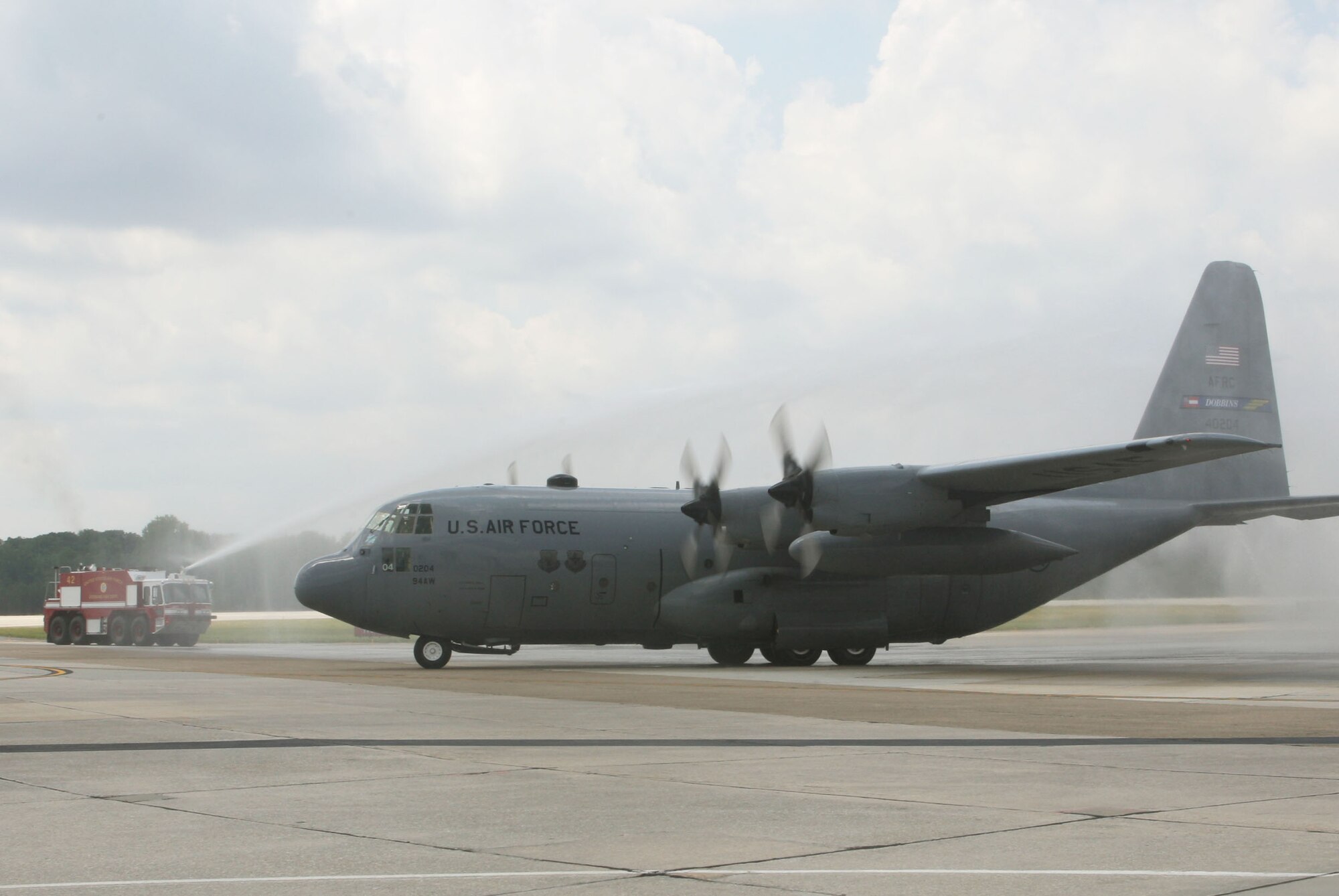 The 94th Civil Engineer Squadron Fire Department hoses down the C-130 Lt. Col. Ricardo “Ricky” Soto piloted as he taxis in from his final flight here June 20. (U.S. Air Force Photo/Don Peek) 