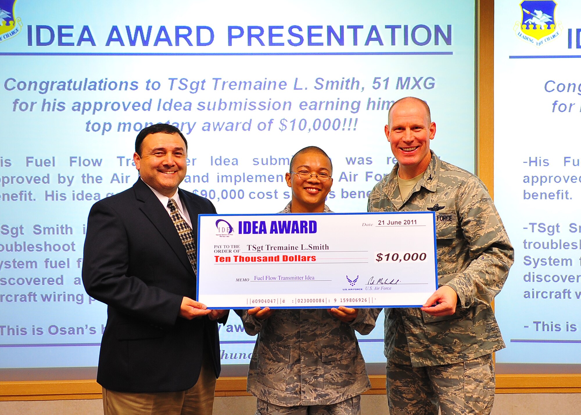 Col. Patrick Malackowski and Ed Moreno present Tech. Sgt. Tremaine Smith with a check for $10,000 here June 21. Sergeant Smith was recognized through the IDEA program for an idea that fixed a fuel-flow transmitter problem saving the Air Force more than $90,000 in replacement costs over the next year. (U.S. Air Force photo/Senior Airman Evelyn Chavez)