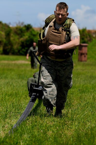Staff Sgt. Ryan Hemenway, 18th Logistic Readiness Squadron Fuel Service Center supervisor and Forward Area Refueling Point tryouts competitor, squeegees a fuel hose as part of the FARP tryouts on Kadena Air Base, Japan, June 17. During the obstacle course portion of the tryouts, contestants were timed on their ability to perform everything from dragging the 200-pound hose 300 feet and clearing it with a squeegee, to holding the hose overhead and then performing pushups in the Okinawan heat. (U.S. Air Force photo/Airman 1st Class Maeson L. Elleman)
