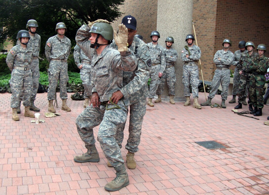 Army Sgt. 1st Class Ronald Wilson, operations noncommissioned officer for the Uniformed Services University of the Health Science, checks Air Force 2nd Lt. John Richardson’s Swiss seat harness as first-year medical students prepare to rappel down a 63-foot wall. DOD photo by Donna Miles