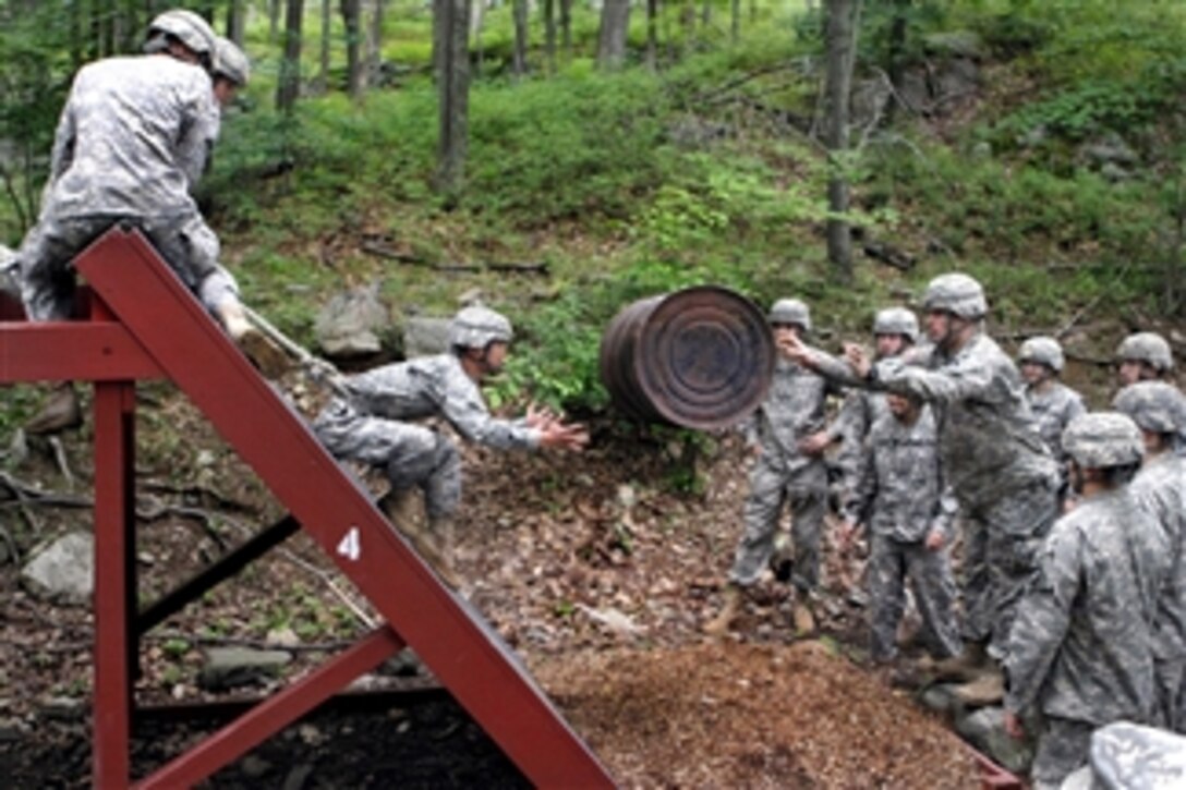 An Army cadet tosses an empty 55-gallon drum to another cadet during the leader reaction course at the U.S. Military Academy at West Point, N.Y., on June 14, 2011.  