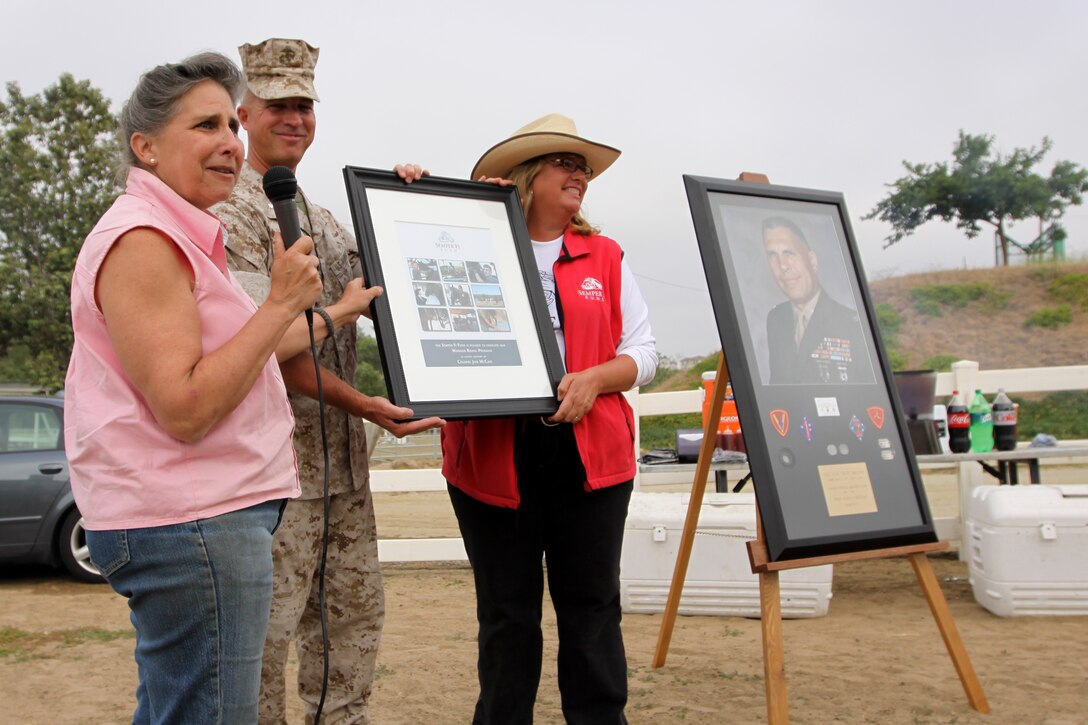(Left to right) Debbie McCain, daughter of Jinx McCain accepts a plaque for her hard work and dedication for making the Jinx McCain Warrior Riding Program possible from Lt. Col. Scott D. Leonard, commanding officer, 1st Light Armored Reconnaissance Battalion, McCain’s former unit and Karen Gunther, president and founder of Semper Fi Fund during a dedication ceremony held at the Camp Pendleton’s Stepp Stables, June 22.