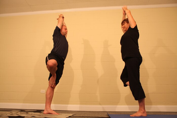 Cheryl LeClair watches Petty Officer 3rd Class Patrick Haslett conduct Yoga exercises at the Second Wind Eco Tours building in Swansboro, N.C. June 23. LeClair provides free yoga and Integrative Restoration, or iRest, therapy to active-duty service members and combat veterans every Thursday evening.