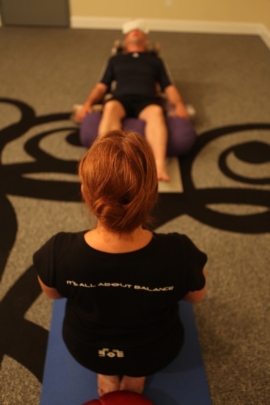 Cheryl LeClair watches Petty Officer 3rd Class Patrick Haslett conduct Yoga exercises at the Second Wind Eco Tours building in Swansboro, N.C. June 23. LeClair provides free yoga and Integrative Restoration, or iRest, therapy to active-duty service members and combat veterans every Thursday evening.