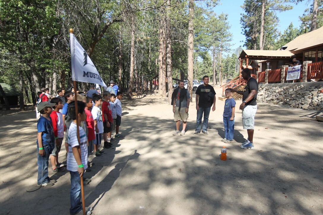 Sergeant Kareem Apulliam, food services specialist with Headquarters Battalion, teaches the campers of Mustang cabin how to drill during Operation Purple at Camp Nawaka, Big Bear, Calif., June 23, 2011. Operation Purple invited Marines and soldiers to come out and spend a day with the kids.::r::::n::