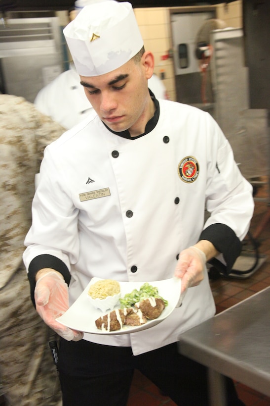 Lance Cpl. Adam Valentin, a food service specialist with Headquarters and Headquarters Squadron, adds finishing touches to his meal of beef cordon bleu, spicy brown pilaf and broccoli parmesan before the start of the chef of the quarter judgment at the Cherry Point mess hall June 23.