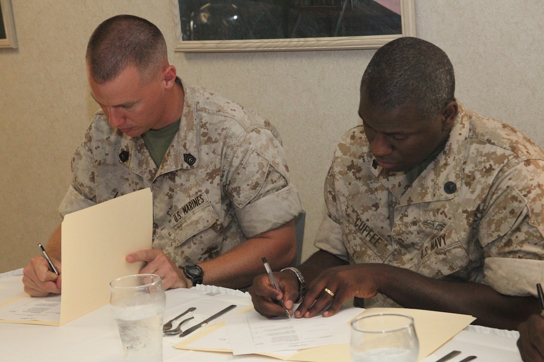 Gunnery Sgt. Timothy J. Lindeman, left, acting company first sergeant of Marine Wing Support Squadron 274’s Engineer Company, and Petty Officer 2nd Class Paul E. Cuffee, a religious program specialist with the air station, make final decisions on the competitors meal taste and appearance during the chef of the quarter competition at the mess hall June 23.