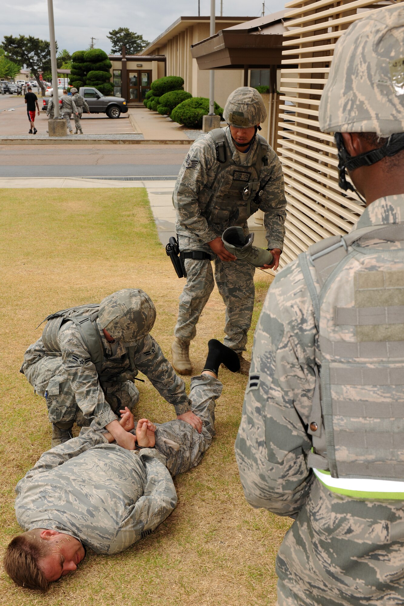 KUNSAN AIR BASE, Republic of Korea -- Airman 1st Class Anthony Alexander, 8th Security Forces Squadron response force leader, searches an active shooter for weapons while Airman 1st Class Nicholas Simmons(right) and Staff Sgt. Charlton Mason(middle), 8th Security Forces Squadron security forces members, provide security here during an emergency management exercise June 22. An active shooter is an individual actively engaged in killing or attempting to kill people in a confined and populated area, typically through the use of firearms. (U.S. Air Force photo/Senior Airman Ciara Wymbs) 