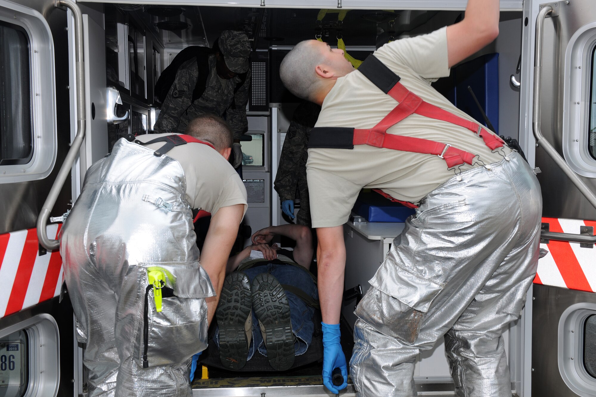 KUNSAN AIR BASE, Republic of Korea -- Airmen from the 8th Civil Engineer Squadron and 8th Medical Group, work together to load a patient into an ambulance during an emergency management exercise here June 22. The EME was conducted to enhance counter-terrorism measures and prepare responders for real life situations. (U.S. Air Force photo/Senior Airman Ciara Wymbs) 