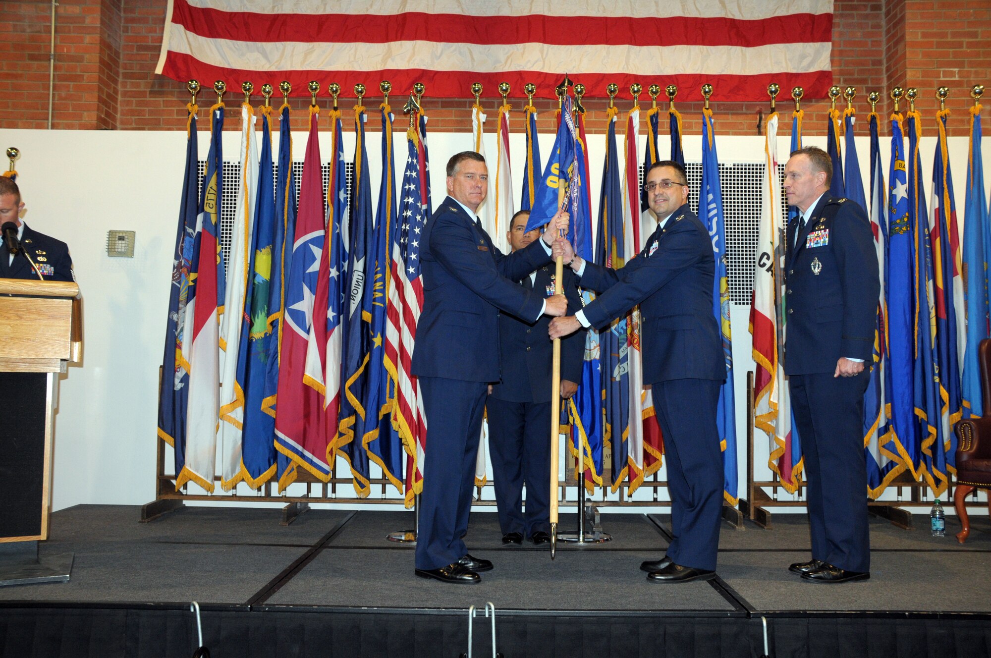 Col. Greg Tims, 90th Missile Wing commander presents the guidon for the 90th Mission Support Group to Col. Timothy Dodge, new 90th MSG commander during the change of command ceremony for the 90th MSG in the Fall Hall Community Center Monday. (U.S. Air Force photo by Blaze Lipowski)
