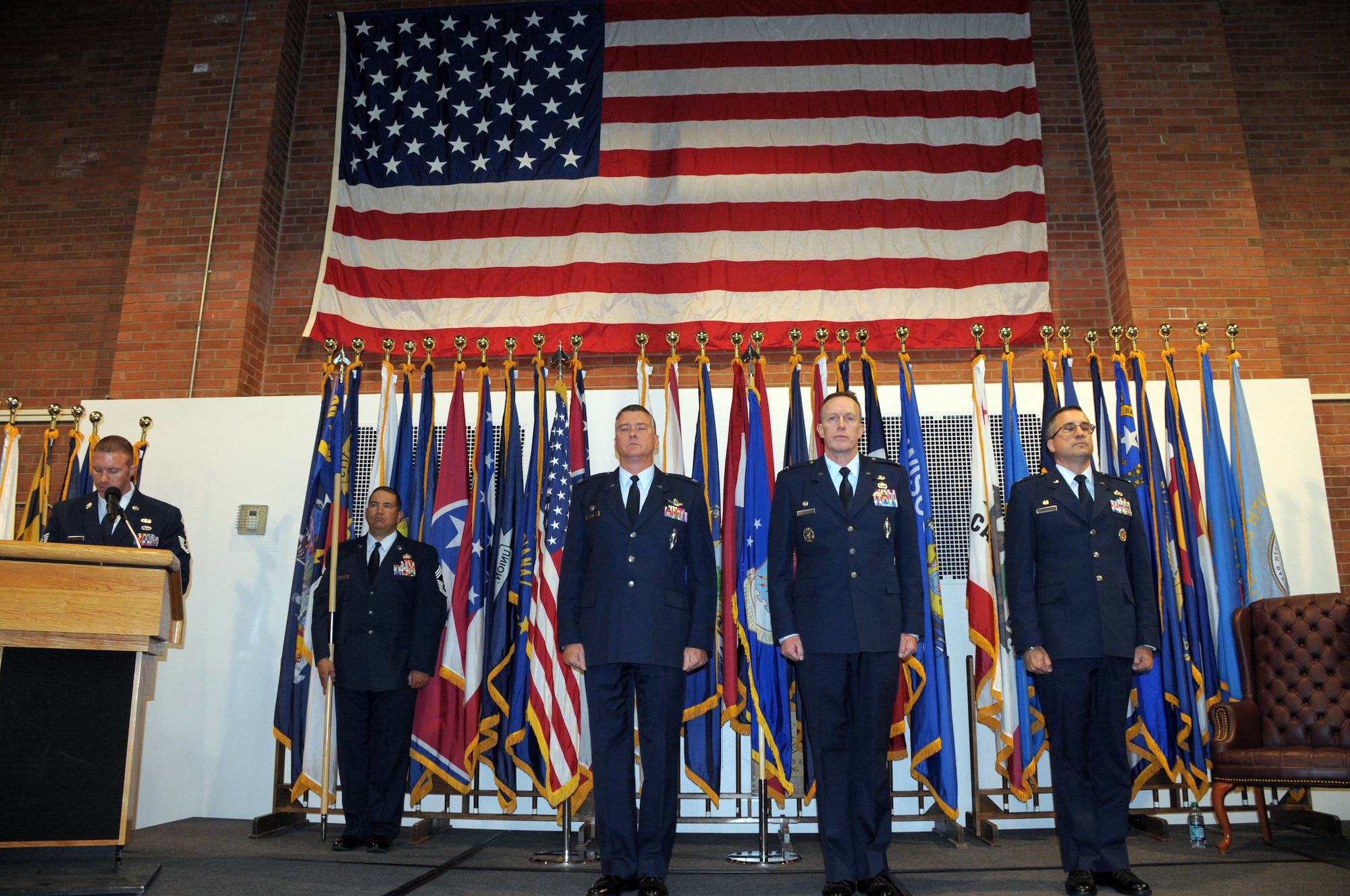 Chief Master Sgt. Jimmie Williams, 90th Mission Support Group command  chief, holds the guidon as Col. Greg Tims, 90th Missile Wing commander, stands at attention with Col. John Boyle, 90th MSG outgoing  commander, Col. Timothy Dodge, incoming commander of the 90th MSG during the 90th MSG change of command in the Fall Hall Community Center Monday. (U.S. Air Force photo by Blaze Lipowski)