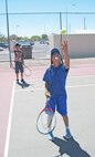 Kirtland Air Force Base, N.M. -- Kiara Kyle practices tossing the ball — the first step in learning how to serve — during a tennis camp hosted by the Youth Center here June 22. (Air Force photo by Jonathan Rejent.) 