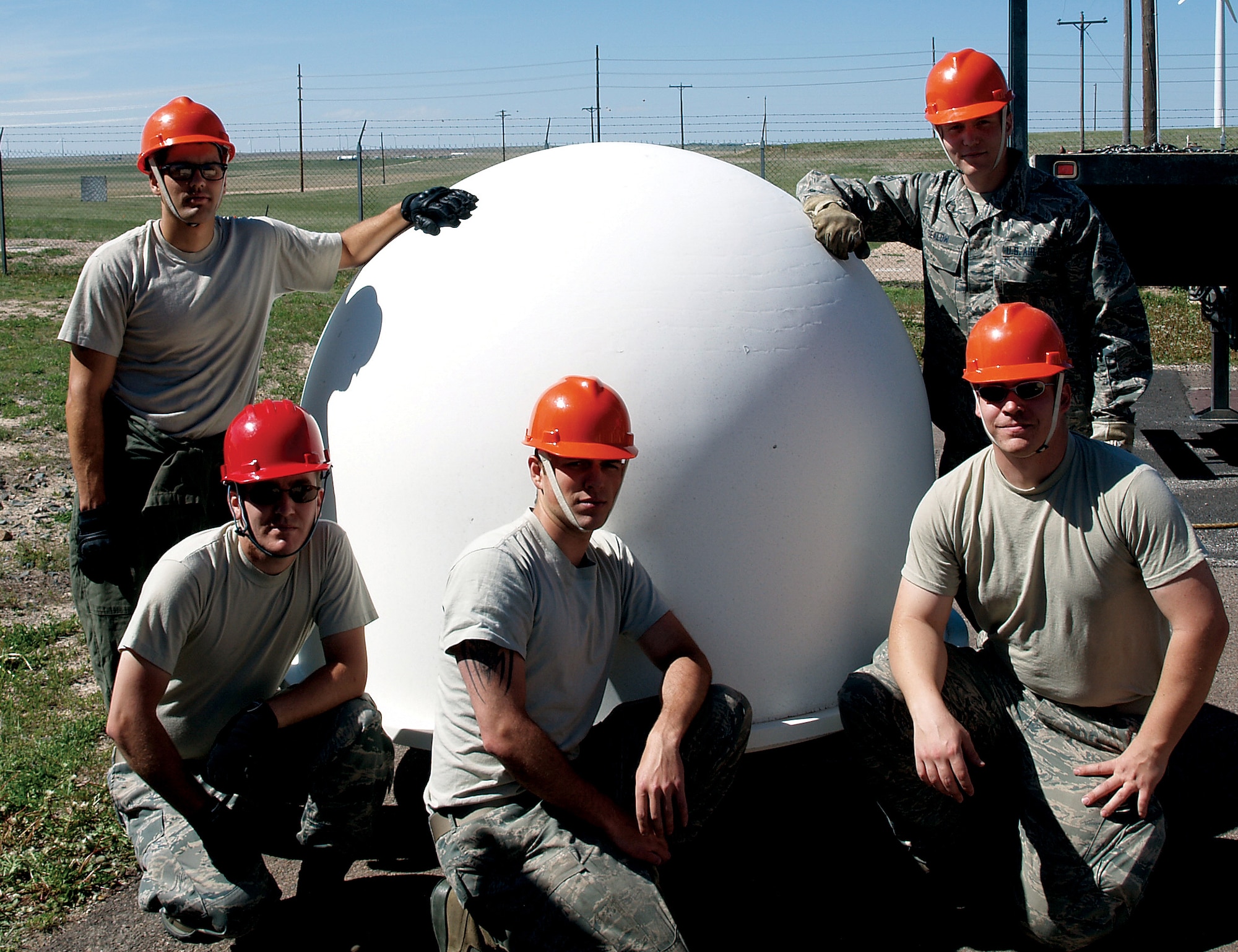 Senior Airman Manuel Desouza, Senior Airman Shawn Gealaw, Staff Sgt. Justin Gress, Staff Sgt. Christopher Scherch and Staff Sgt Shawn Allen, all with the 90th Missile Maintenance Squadron, pose in front of the radome recently removed from Missile Alert Facility Charlie-01. The maintenance team, along with Staff Sgt. Steven Powers, Senior Airman Matthew Cannon, Senior Airman Jarrick Chappell and Airman 1st Class Kyle Wiens, also with the 90th MMXS, were responsible for the ISST decommissioning project. (U.S. Air Force Photo by Capt. Toby Smith)