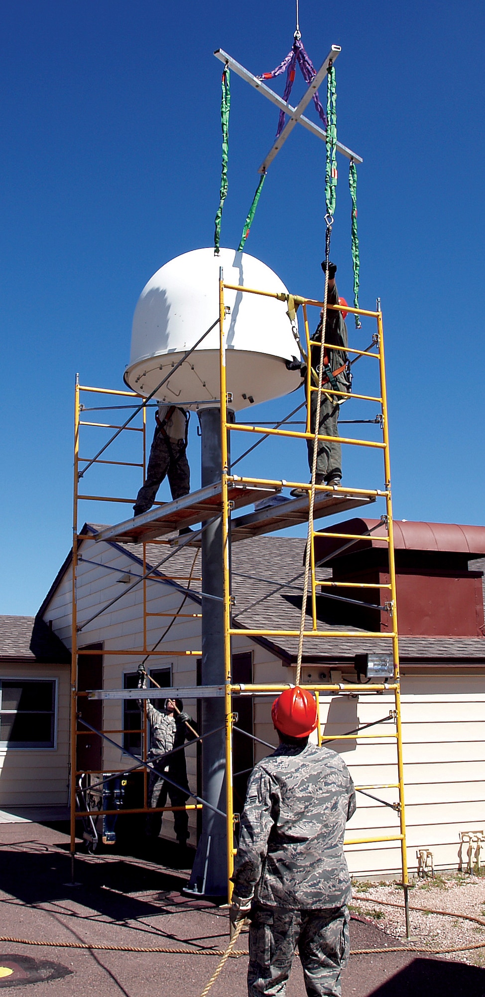 Staff Sgt. Shawn Allen and Senior Airman Shawn Gealow help Staff Sgt Christopher Scherch and Senior Airman Manuel Desouza, all from the 90th Missile Maintenance Squadron, secure the wing's last remaining radome to a crane at Missile Alert Facility Charlie-01, June 2. With the removal of this radome and mast assembly, Warren became the first wing in 20th Air Force to complete the decommission of the ICBM Super High Frequency Satellite Terminal. (U.S. Air Force Photo by Capt. Toby Smith)