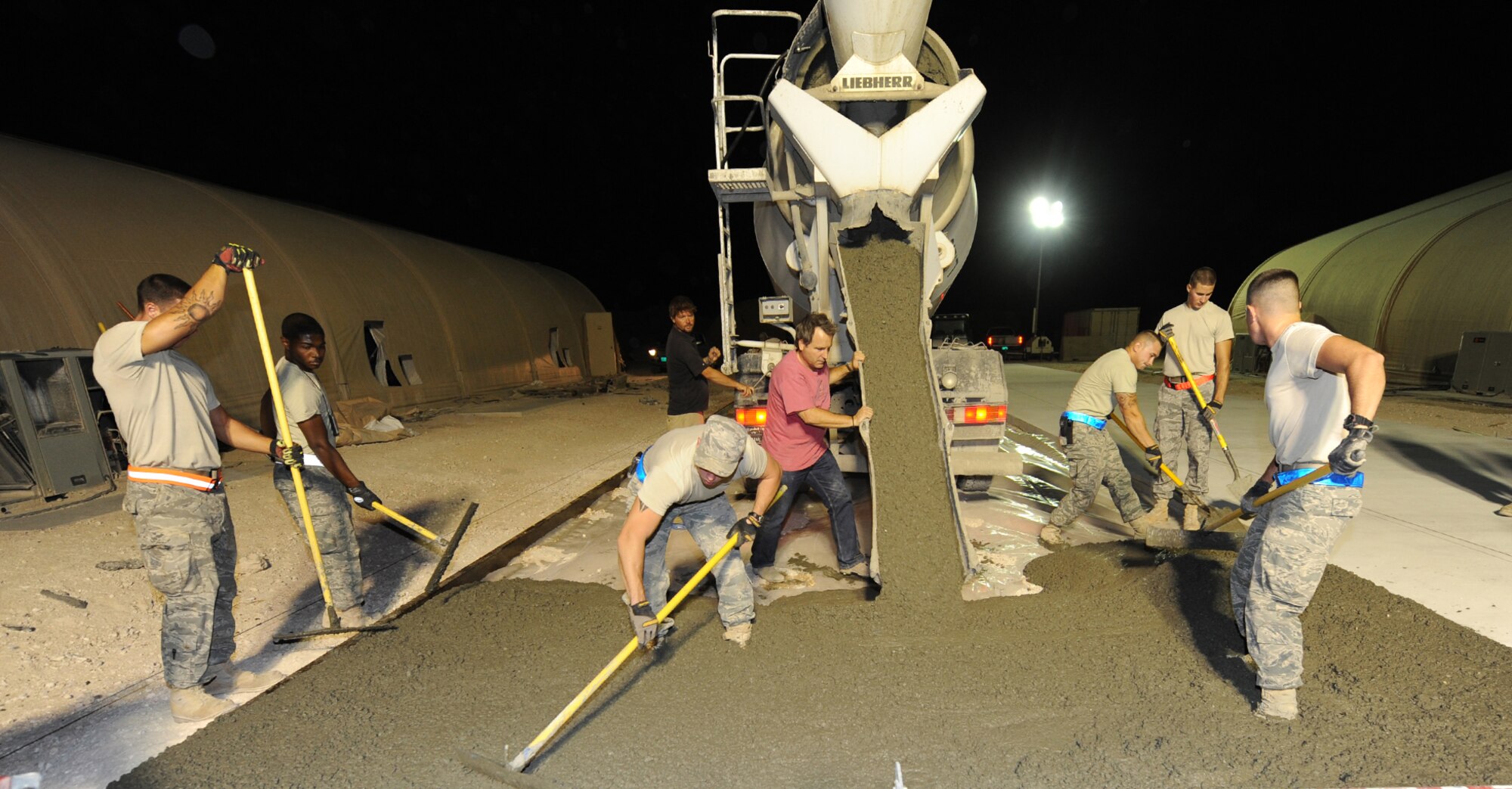 Airmen assigned to the 379th Expeditionary Civil Engineer Squadron spread concrete June 15, 2011, as part of a project in Southwest Asia. (U.S. Air Force photo/Staff Sgt. Liliana Moreno)
