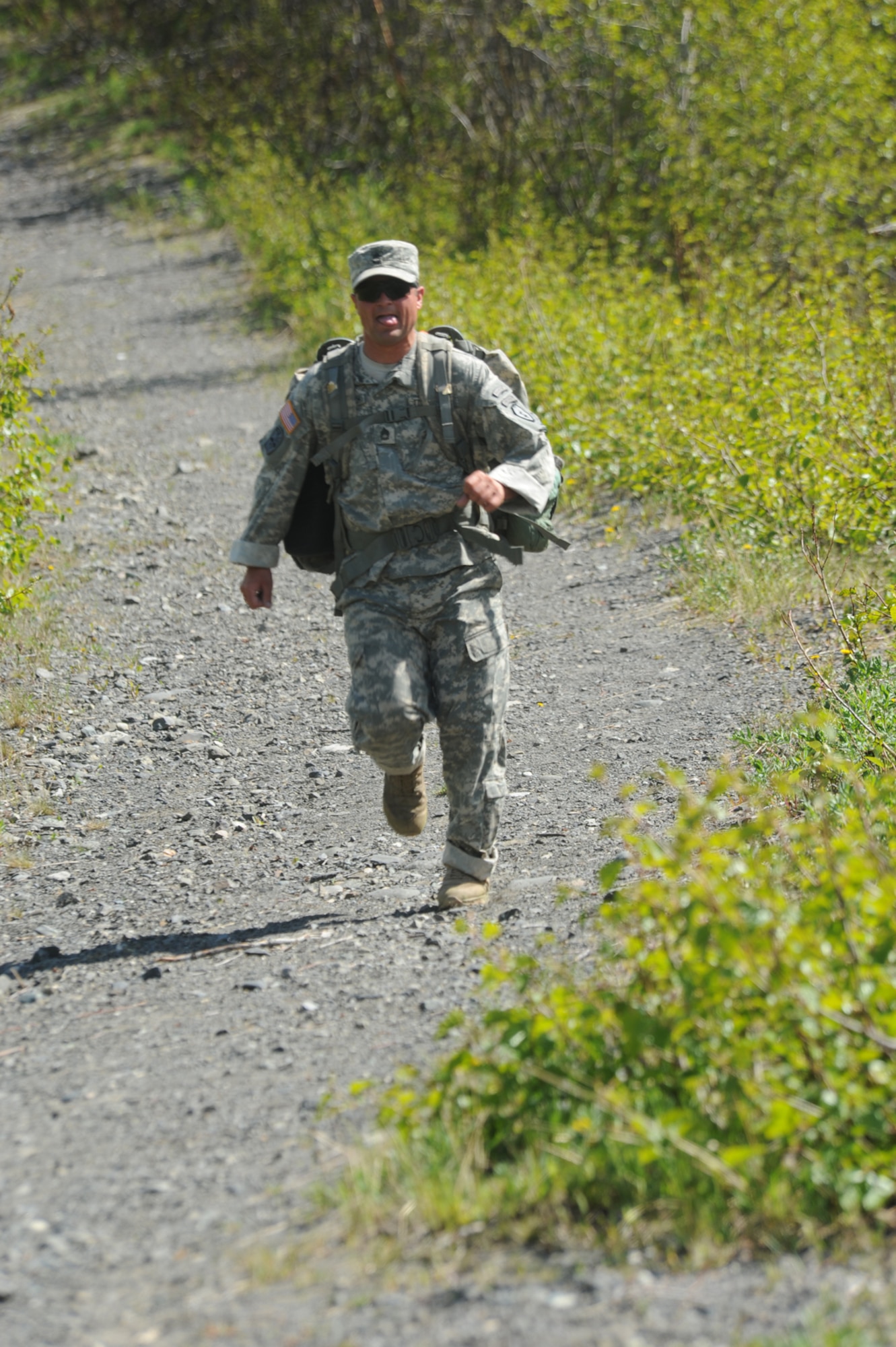 Sgt. 1st Class Joshua Lothspeich of 3rd Battalion (Airborne), 509th Infantry Regiment, picks up the pace on the downhill slope near the finish line of the 5K race June 17. Lothspeich finished first with a time of 23.45 minutes for the race. To participate in the Combat Cross Country series, contact Buckner Physical Fitness center at 384-1308.  (U.S. Air Force photo/Steve White)