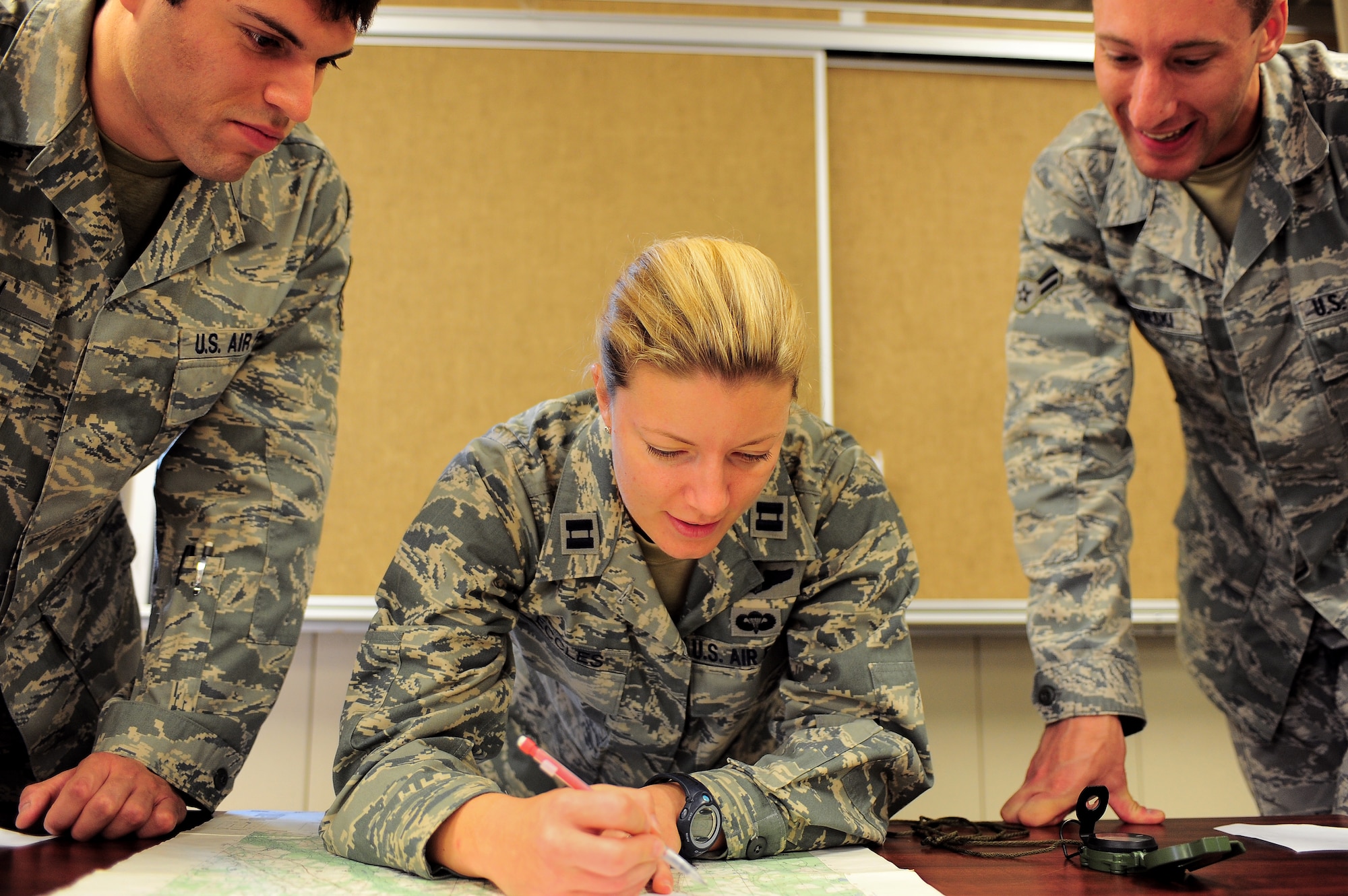 Capt. Sarah Eccles plots coordinates on a map June 10, 2011, as Staff Sgt. Lucas Smith and Airman 1st Class Kyle Gutowski observe. The three are assigned to the 682nd Air Support Operations Squadron at Shaw Air Force Base, S.C.  Captain Eccles, an F-16 Fighting Falcon pilot, currently is serving in a career-broadening assignment as an air liaison officer in the 682nd ASOS.  (U.S. Air Force photo/Airman 1st Class Daniel Phelps)