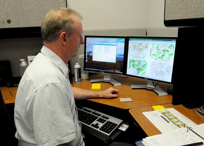 Terance Roberts, a weather forecaster with the 12th Operations Support Squadron, Randolph Air Force Base, Texas, studies a computer model to determine a weather forecast. (U.S. Air Force photo/Dave Terry)