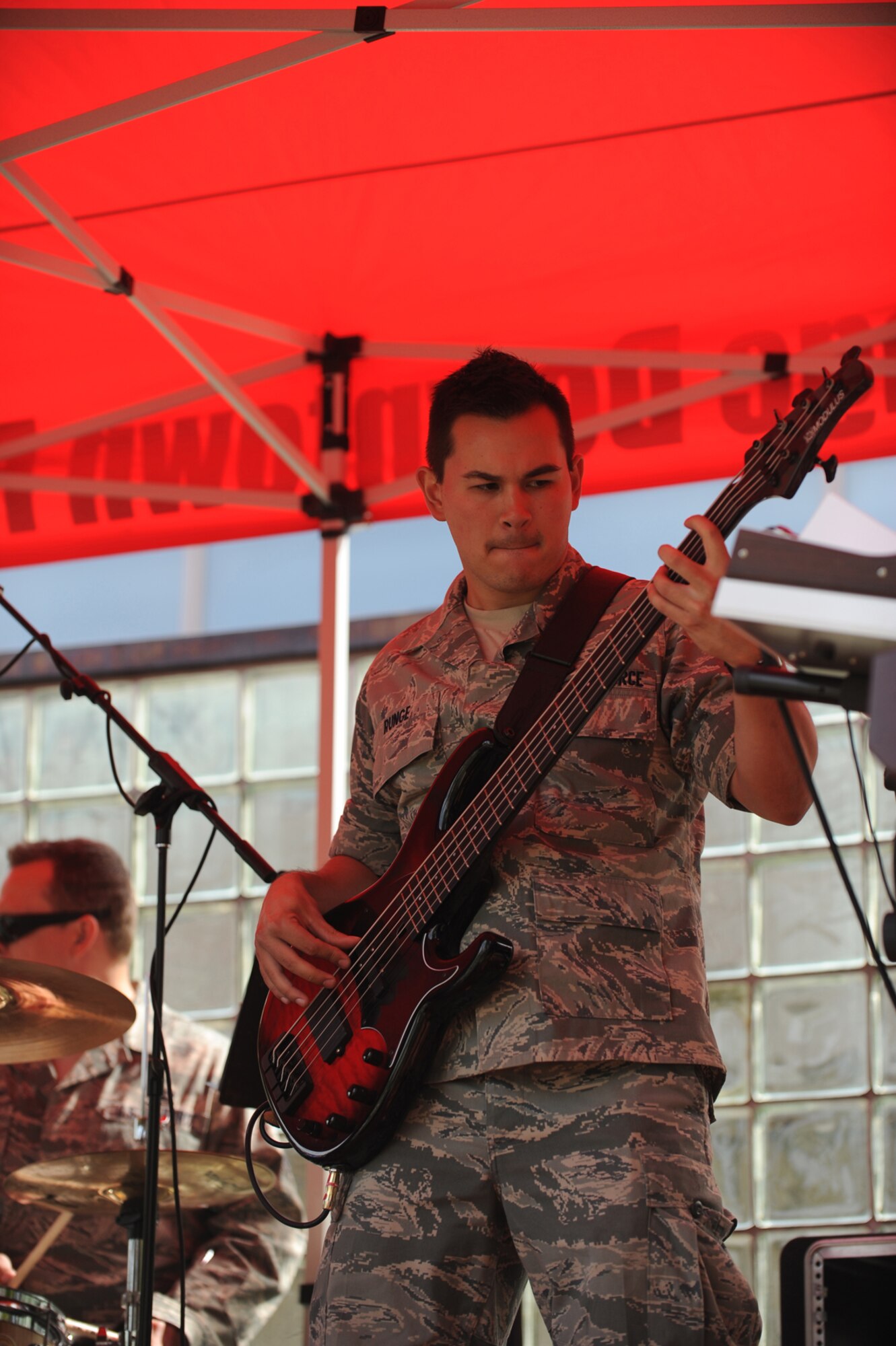 Airman 1st Class Philip Runge, bass player for the Air Force Band of the
Pacifi c’s rock band Top Cover, performs for the crowd following the Hero Games in
downtown Anchorage, Alaska, June 18. (U.S. Air Force photo\Steve White)