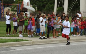 Keshawn Downing, 12, runs the torch to the Youth Center to open the games June 22.  The Youth Center staff as well as other agencies on base worked together to organize several competitions for the children to participate in. (U.S. Air Force photo by Senior Airman Torey Griffith)