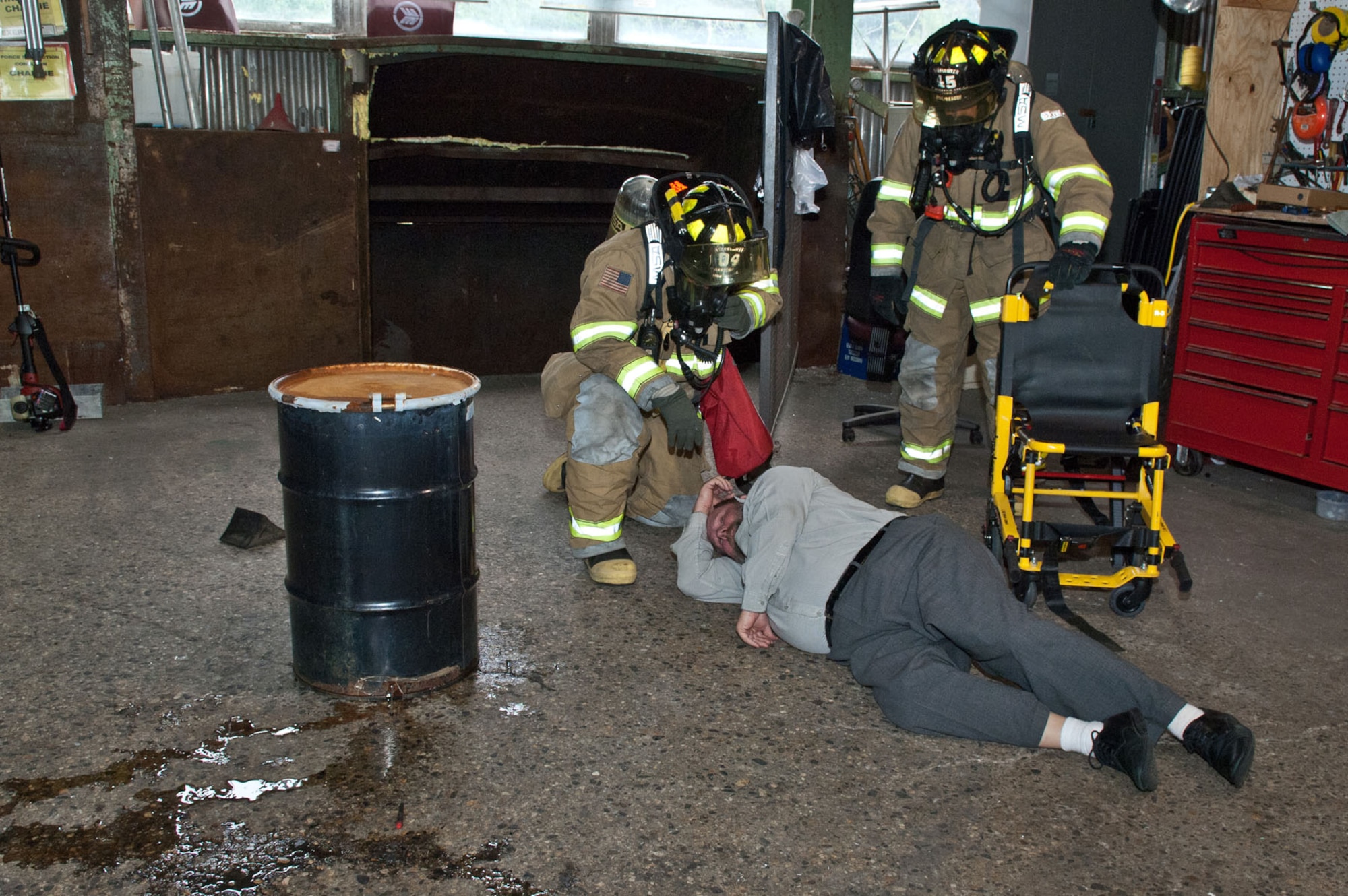 HANSCOM AIR FORCE BASE, Mass. – Hanscom firefighters attend to a person who collapsed after trying to dump hazardous materials at the solid waste transfer station near Camp Patriot June 14. As part of the HAZMAT scenario, the suspect was transported to a local hospital and bioenvironmental engineering technicians cleaned up the spill. (U.S. Air Force photo by Rick Berry)