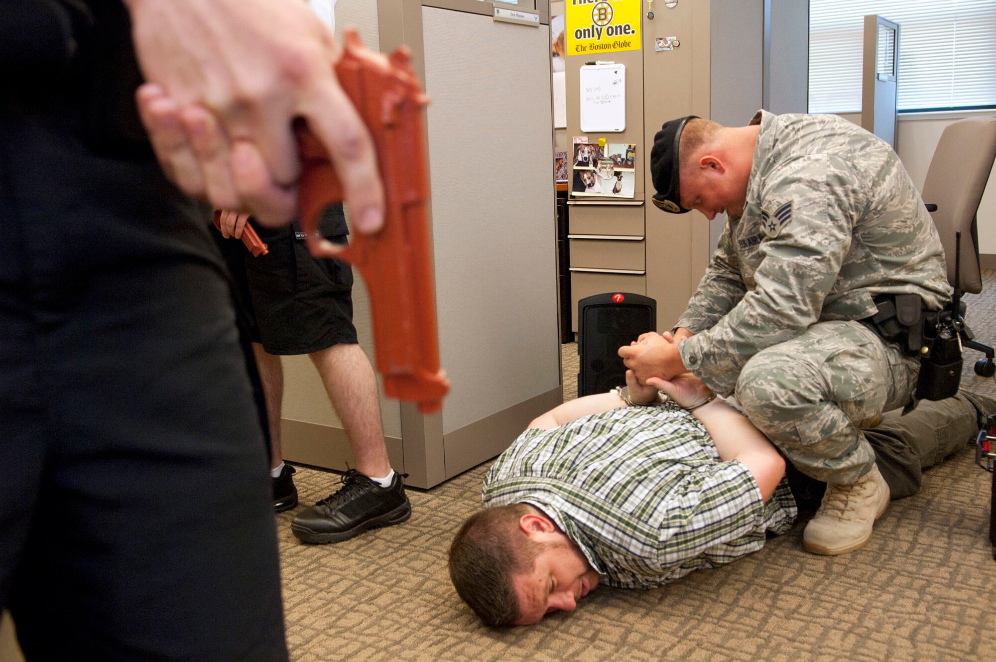HANSCOM AIR FORCE BASE, Mass. - Senior Airman Nicholas Witters handcuffs the suspect, Tim Crincic, during an active shooter exercise in Building 1604 June 16.The 66th Security Forces Squadron responded to the active shooter incident as part of the Base Readiness Exercise last week. (U.S. Air Force photo by Mark Wyatt)