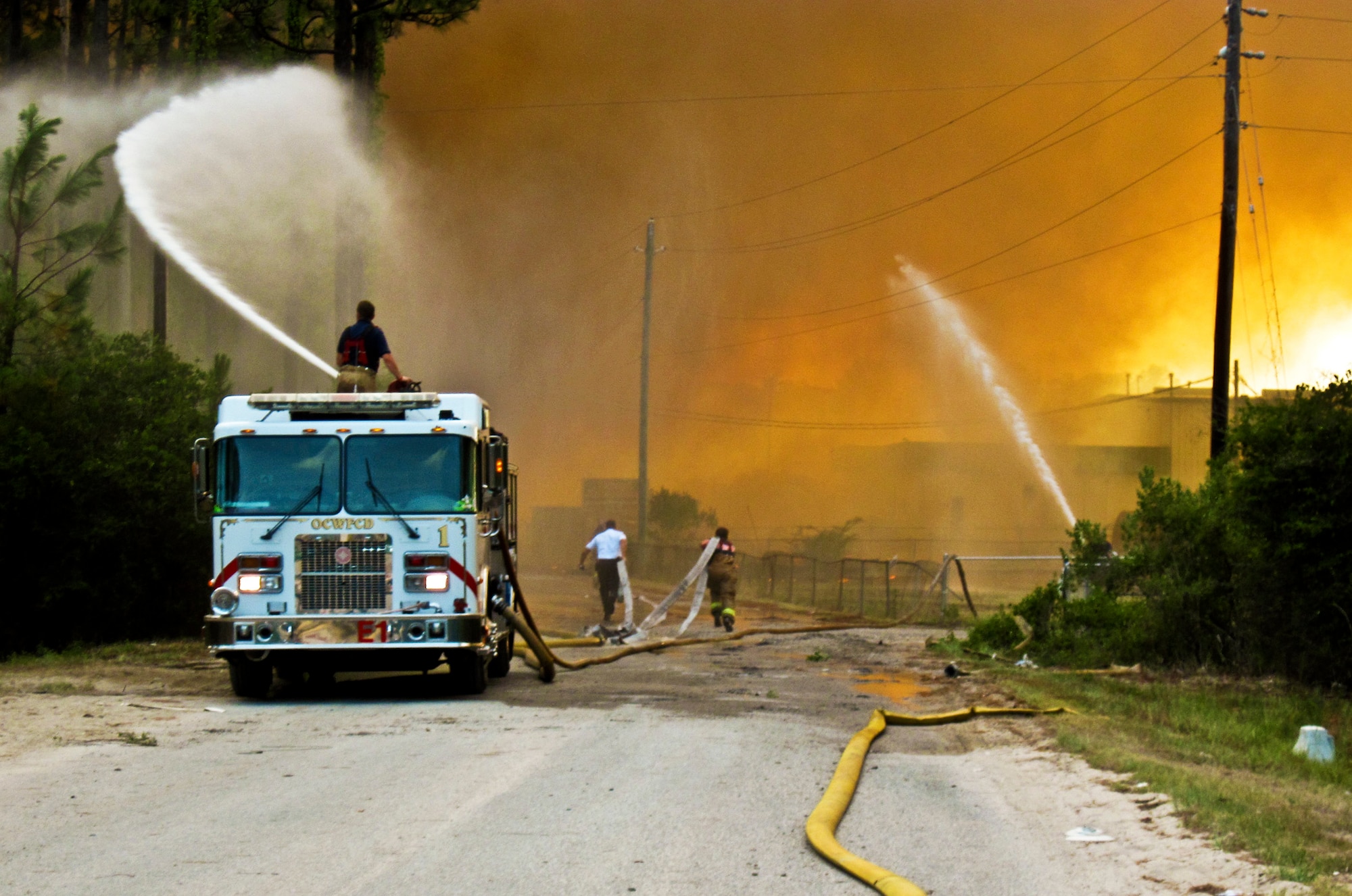 Firefighters from Eglin Fire Department and Jackson Guard work with the Ocean City/Wright and Fort Walton Beach Fire Departments to contain two urban-interface wildfires within the same vicinity on Eglin reservation, June 22.  Northwest Florida is in the midst of a severe drought and is 15 inches below normal rainfall for the year.  The wildfires burned more than 15 acres of forest and threatened homes and businesses, but due to firefighting efforts no structures were damaged.  (U.S. Air Force photo/Mike Spaits)