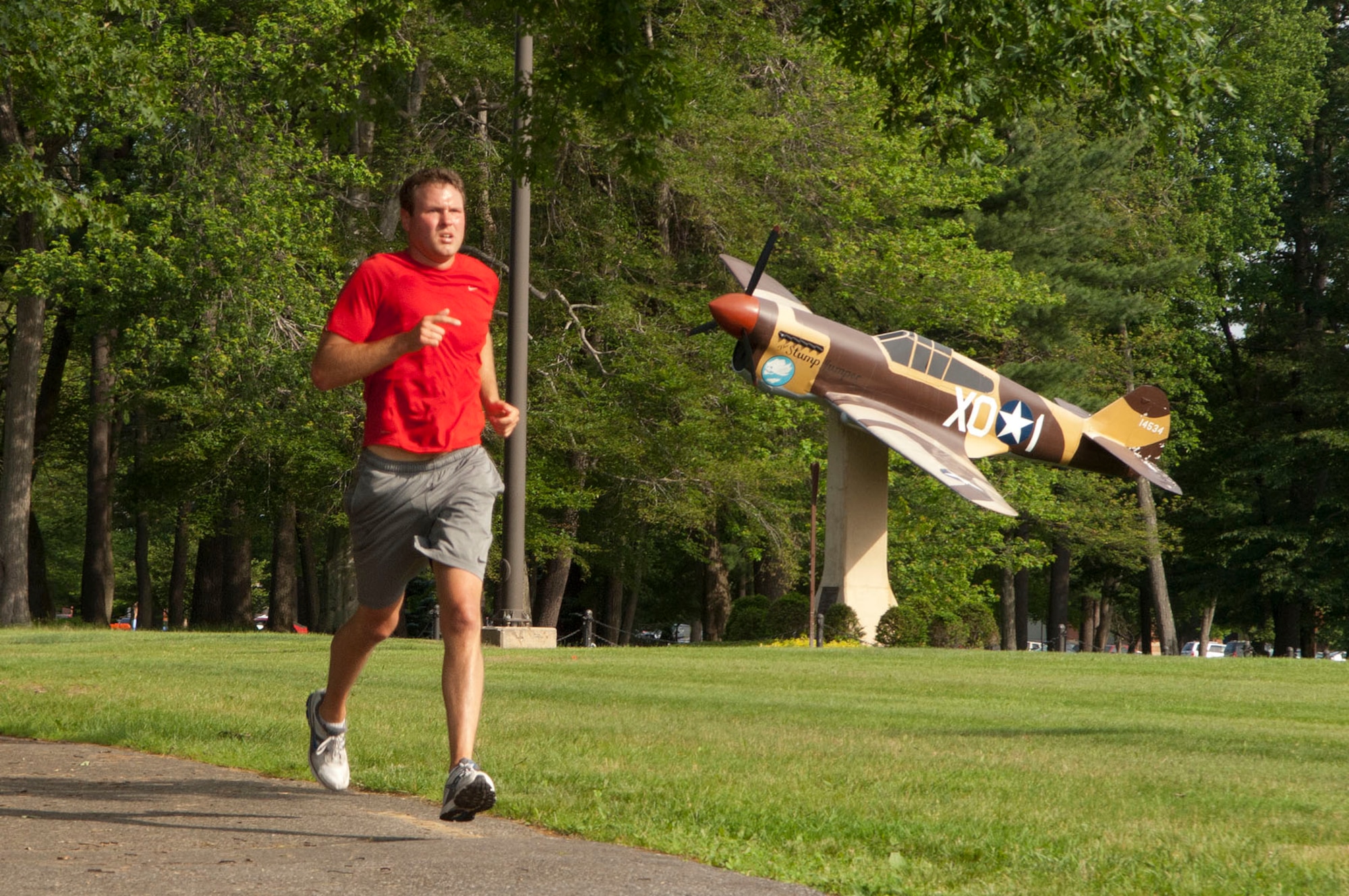 HANSCOM AIR FORCE BASE, Mass. – 1st Lt. Evan Dadosky, Battle Management Directorate, runs past the P-40 static aircraft display during the Summer Thunder 10K June 15. Lieutenant Dadosky placed first in the male category with a finish time of 41:50 and Mellissa Davidson, 319th Recruiting Squadron, placed first in the female category with a time of 47:39. (U.S. Air Force photo by Mark Wyatt)