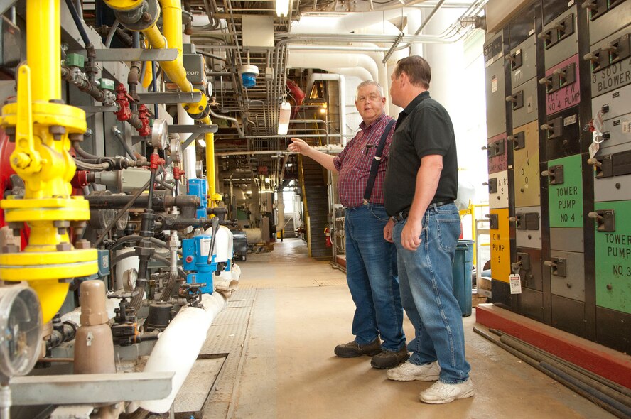 HANSCOM AIR FORCE BASE, Mass. – Lawrence Morton (left), steam plant supervisor, discusses operations with Leo Shortsleeve, stationary engineer, inside the steam plant June 14. Mr. Morton began his career at Hanscom as an Airman in 1964. He has worked at the plant for 47 years. (U.S. Air Force photo by Mark Wyatt)