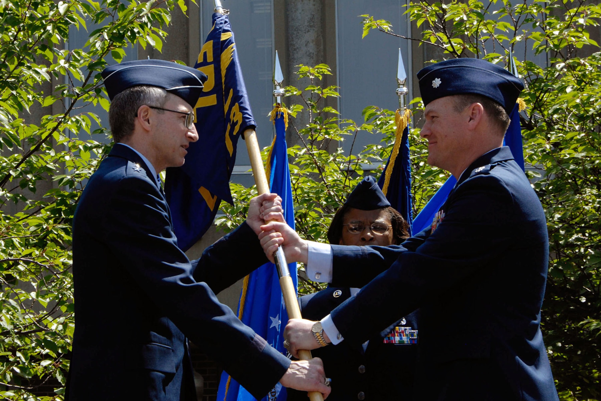 HANSCOM AIR FORCE BASE, Mass. - Lt. Col. Jeffrey R. Stutz, commander, Air Force Research Laboratory Hanscom Research Site, passes the organization's flag to Maj. Gen. William N. McCasland, commander, AFRL, during an inactivation ceremony June 15.  The Hanscom site is being closed as part of the Base Realignment and Closure process.  The organization's Space Vehicles Directorate is moving to Kirtland AFB in Albuquerque, N.M., while the Sensors Directorate is headed to Wright-Patterson AFB in Dayton, Ohio.  (U.S. Air Force photo by Linda LaBonte-Britt)