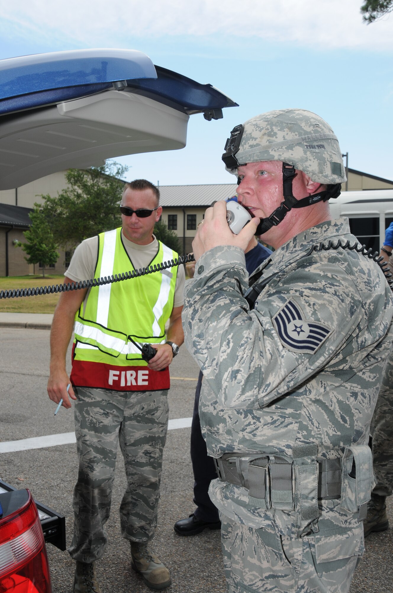 Tech. Sgts. Scott Anderson, fire operations commander, and Billy Walker, 81st Security Forces Squadron onscene commander, report pertinent information during Keesler's active shooter exercise, June 21-22.  In the exercise, a lone gunman opened fire at Airman Leadership School, with 12 people killed and 17 injured.  The exercise, conducted by Air Education and Training Command, tested the base's ability to respond and recover from a mass casualty event.  (U.S. Air Force photo by Kemberly Groue)