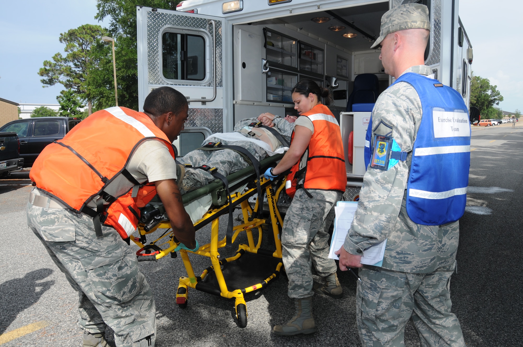 Airmen 1st Class Vincent Soles, left, and Ashley Figueroa, 81st Aerospace Medicine Squadron, load Staff Sgt. Derrick Gerlich, 81st Logistics Readiness Squadron, into an ambulance headed to Keesler Hospital during the base's active shooter exercise, June 21-22.  Observing at right is Master Sgt. Josh Sigler, 81st Medical Group, a member of the 81st Training Wing's exercise evaluation team.  Sergeant Gerlich portrayed the lone gunman who opened fire at Airman Leadership School, with 12 people killed and 17 injured.  The exercise, conducted by Air Education and Training Command, tested the base's ability to respond and recover from a mass casualty event.  (U.S. Air Force photo by Kemberly Groue)