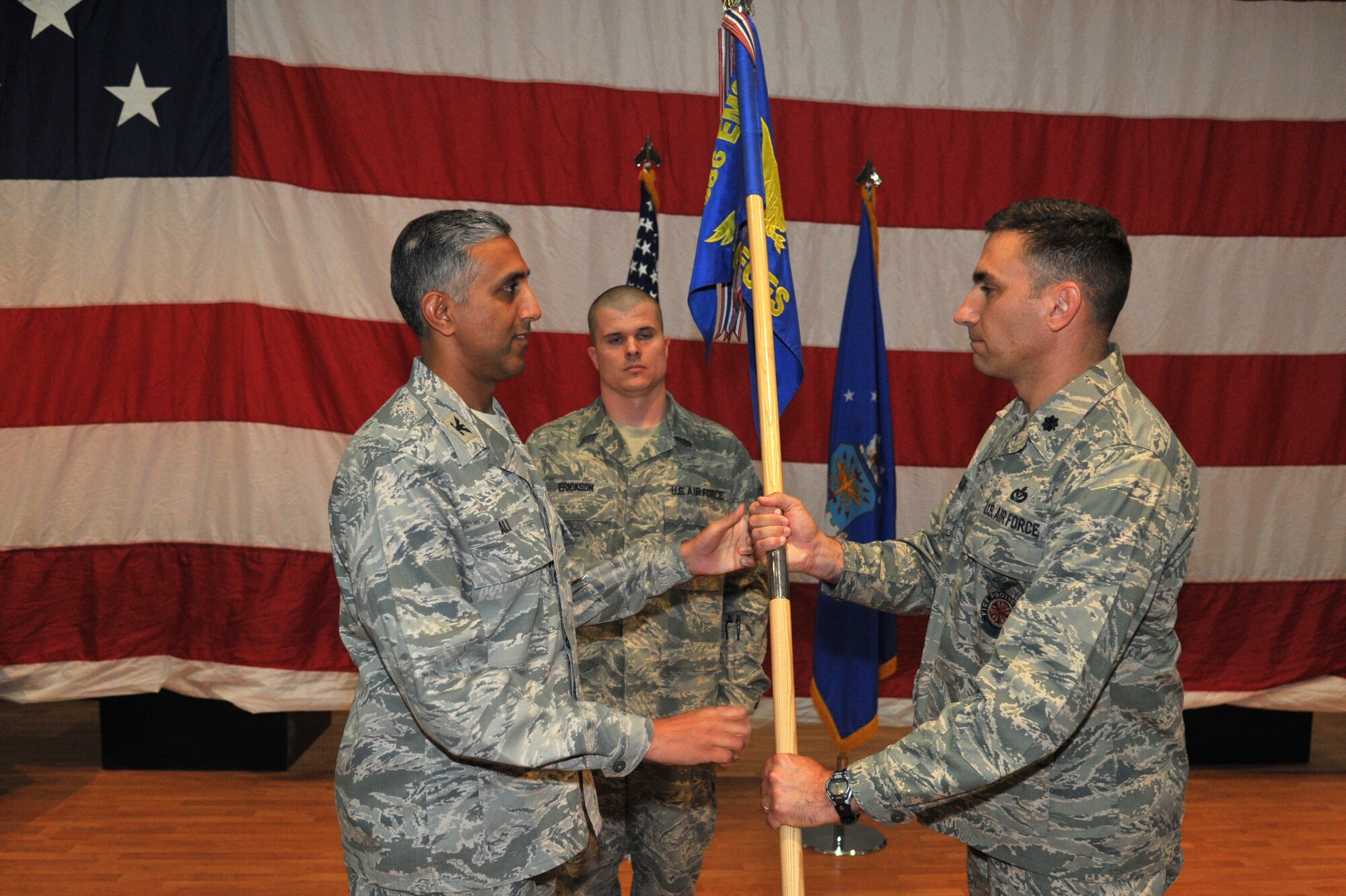 Col. Rizwan Ali, 386th Expeditionary Mission Support Group commander, left, passes the 386th Expeditionary Civil Engineer Squadron guide-on to Lt. Col. Thomas L. Defazio Jr. during a change of command ceremony June 23 at an undisclosed location in Southwest Asia. Lt. Col. Defazio assumed command of the 386th ECES from Lt. Col. Ronald L. Pieri. (U.S. Air Force photo by Master Sgt. Carlotta Holley)