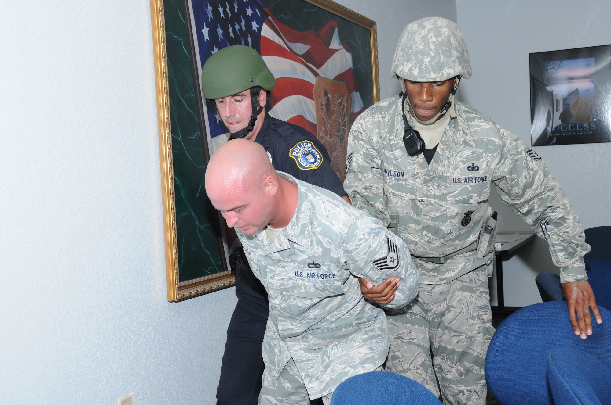 Benjamin Thomas, left, and Staff Sgt. Jermaine Wilson, 81st Security Forces Squadron, escort Staff Sgt. Derrick Gerlich, 81st Logistics Readiness Squadron, after he was "apprehended" during Keesler's active shooter exercise, June 21-22.  Sergeant Gerlich portrayed the lone gunman who opened fire at Airman Leadership School, with 12 people killed and 17 injured.  The exercise, conducted by Air Education and Training Command, tested the base's ability to respond and recover from a mass casualty event.  (U.S. Air Force photo by Kemberly Groue)