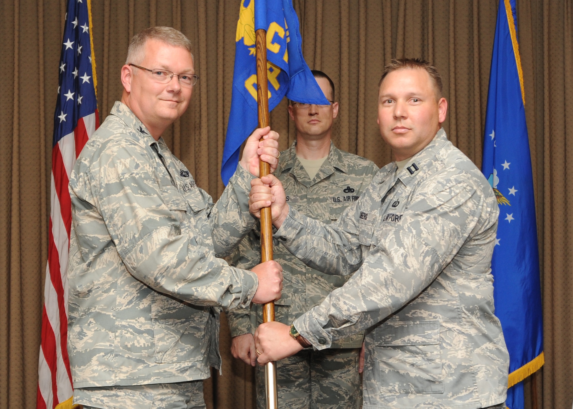 Capt. James E. Oberg receives the 319th Comptroller Squadron guidon from Col. Scott Rizer, 319th Air Base Wing vice commander, during a change of command ceremony June 22, 2011. (U.S. Air Force photo/Staff Sgt. Suellyn Nuckolls)