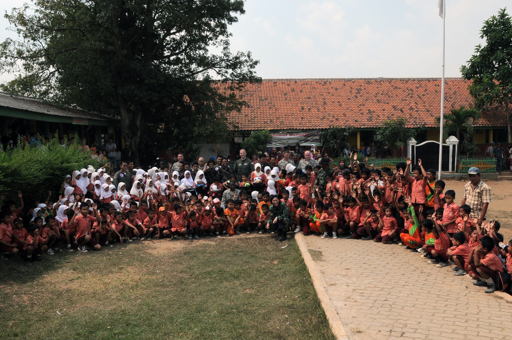 BINGUANG DISTRICT, Indonesia -- Indonesian schoolchildren from the Negri Warakas No. 3 Elementary School take a group picture with U.S. and Indonesian Airmen during a goodwill visit in Binguang district, Indonesia, June 23, 2011. Visiting local Indonesian schools has become tradition for Cope West teams from Yokota Air Base, Japan, with Airmen gathering donations from the base community prior to departing from their home station. (U.S. Air Force photo/Capt. Raymond Geoffroy)