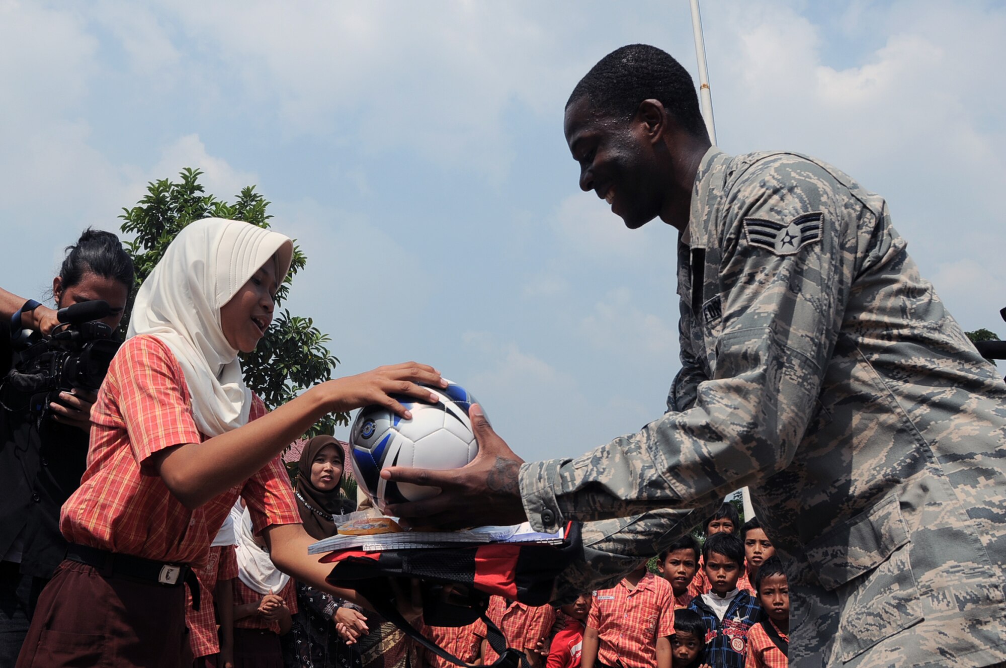 BINGUANG DISTRICT, Indonesia -- Senior Airman Brian Smith, a rigger with the 21st Special Tactics Squadron at Fort Bragg, N.C., gives school supplies to an Indonesian schoolgirl during a goodwill visit to the Negri Warakas No. 3 Elementary School in Binguang district, Indonesia, June 23, 2011. Airmen delivered more than $1,200 worth of school supplies and sports equipment to the school during the visit. (U.S. Air Force photo/Capt. Raymond Geoffroy)