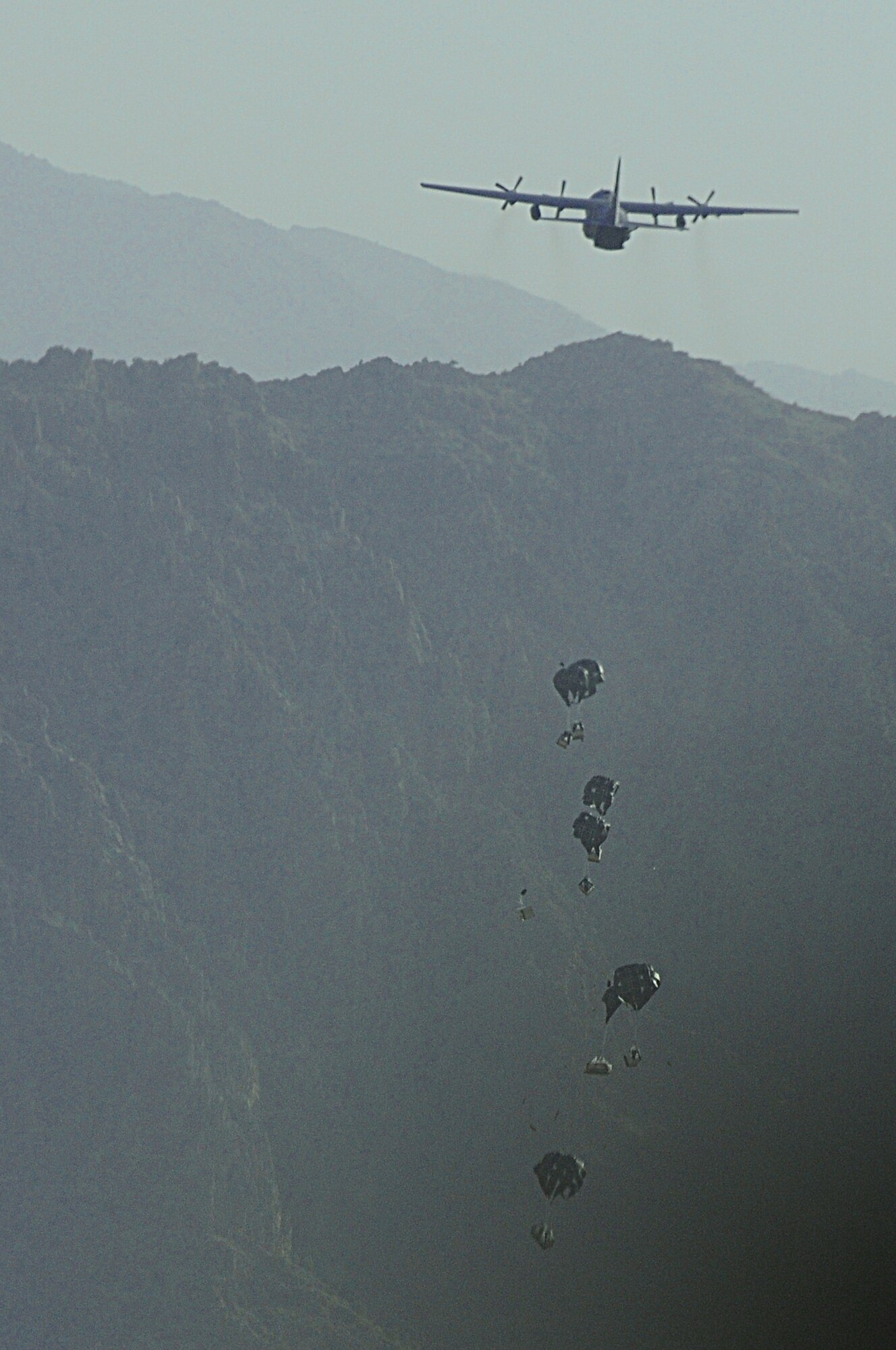 BAGRAM AIRFIELD, Afghanistan -- A C-130 Hercules from the New York Air National Guard airdrops much-needed supplies to a forward operating base in Oruzgan Province, Afghanistan, June 22. The New York ANG C-130 flew the airdrop mission in conjunction with another C-130 from the Alaska ANG. Airdrops help mitigate the danger of transporting supplies via convoy. (U.S. Air Force photo by Senior Airman Krista Rose.)
